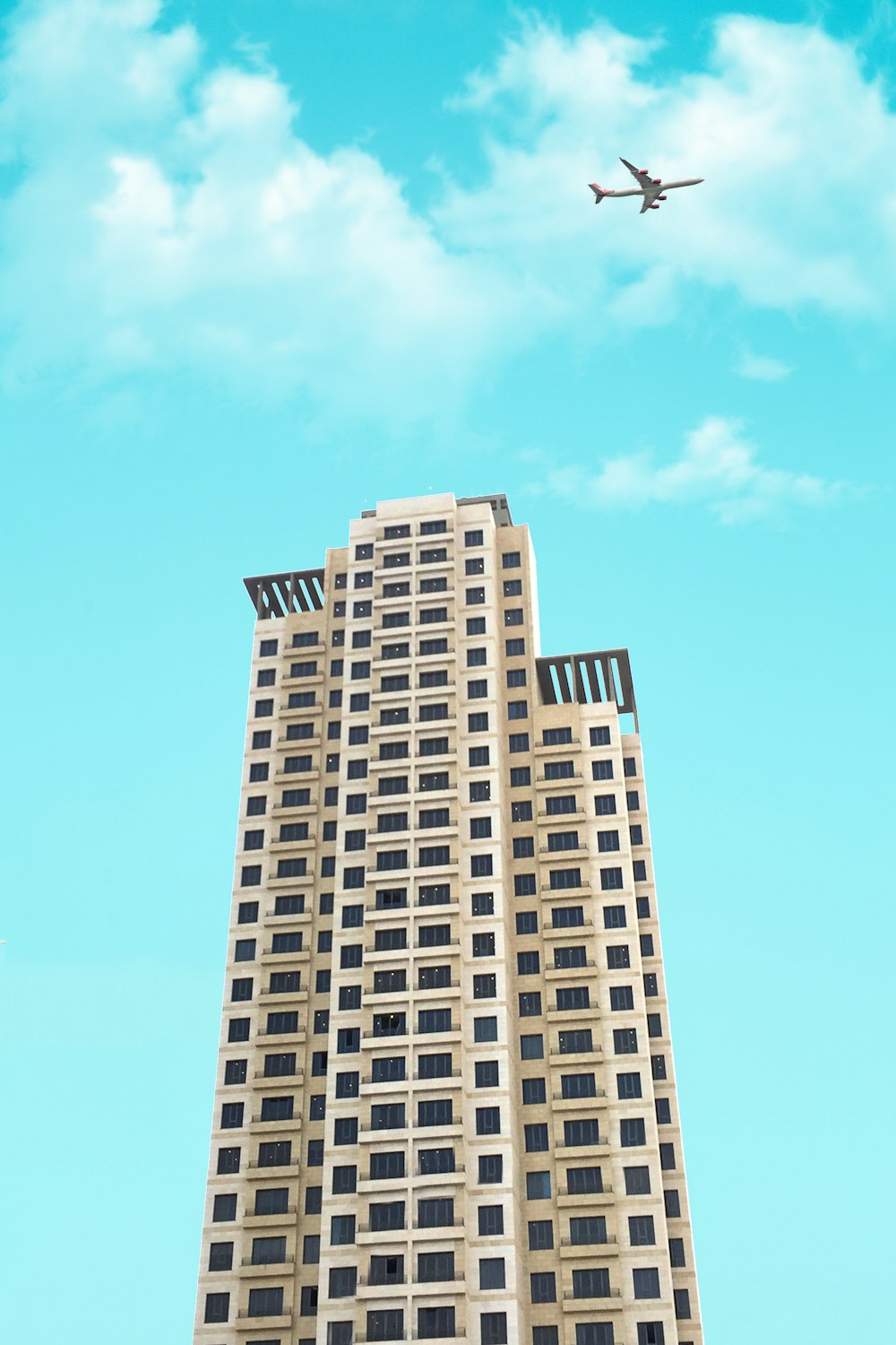 Foto de un edificio blanco de gran altura bajo el cielo azul y blanco