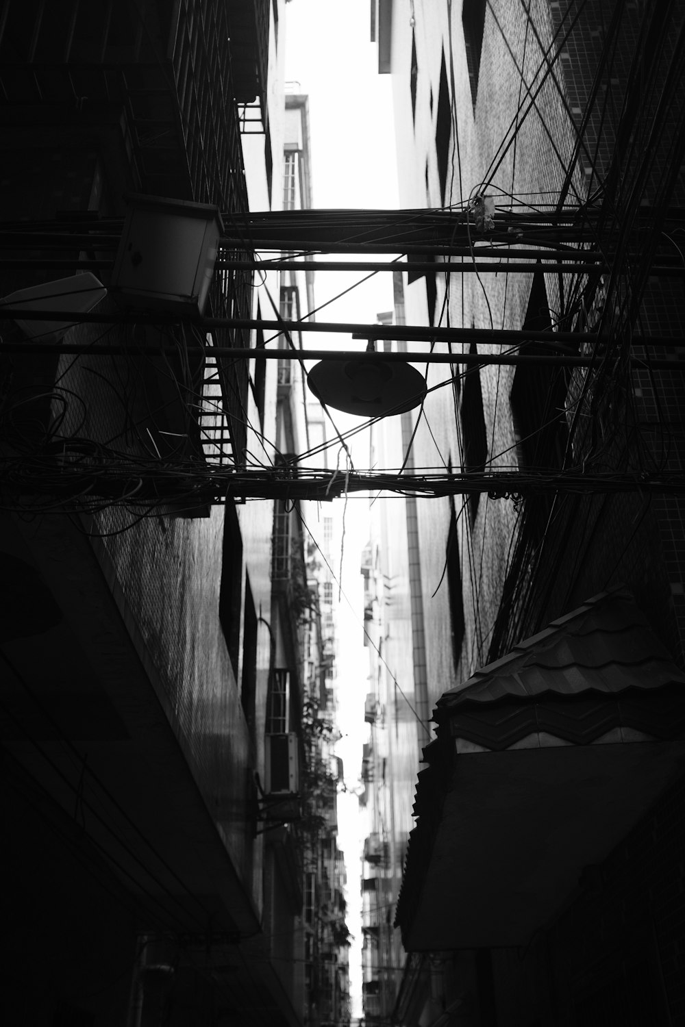 silhouette of cables in between concrete buildings at daytime