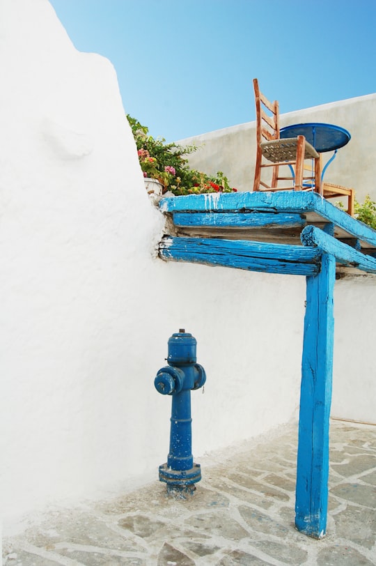 blue hydrant under blue wooden loft with chair on top under blue sky at daytime in Naxos Greece