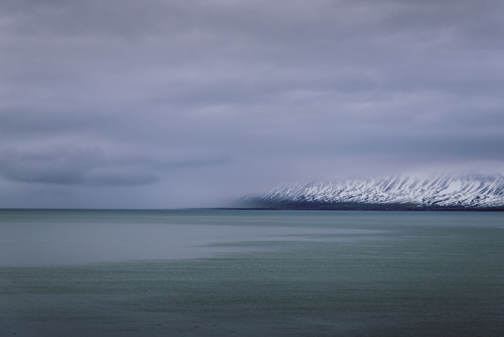 ocean beside of snow mountain