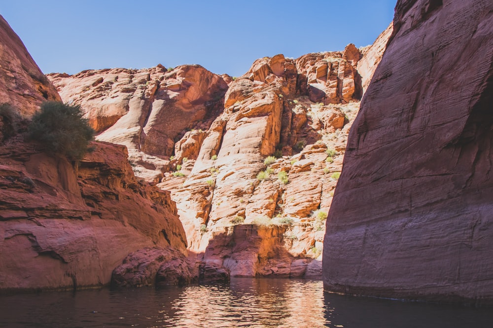 river surrounded of brown cliffs during daytime