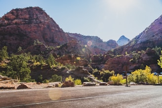 Close-up of a scanner device in use on rocky terrain with lush mountains in the background.