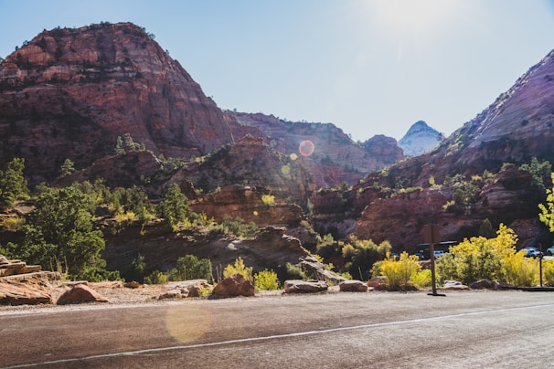 Close-up of a scanner device in use on rocky terrain with lush mountains in the background.