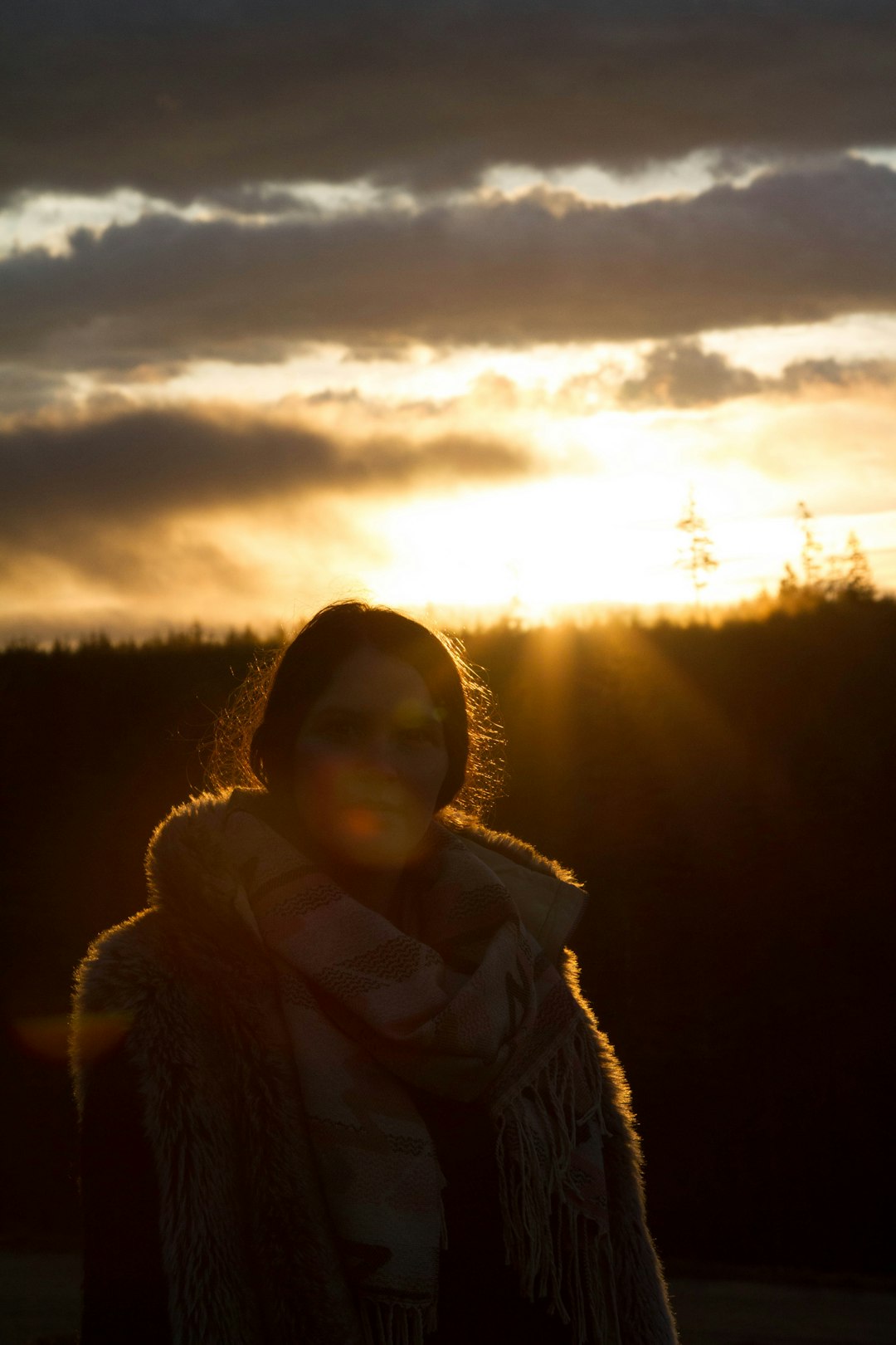silhouette photography of woman wearing scarf standing near trees