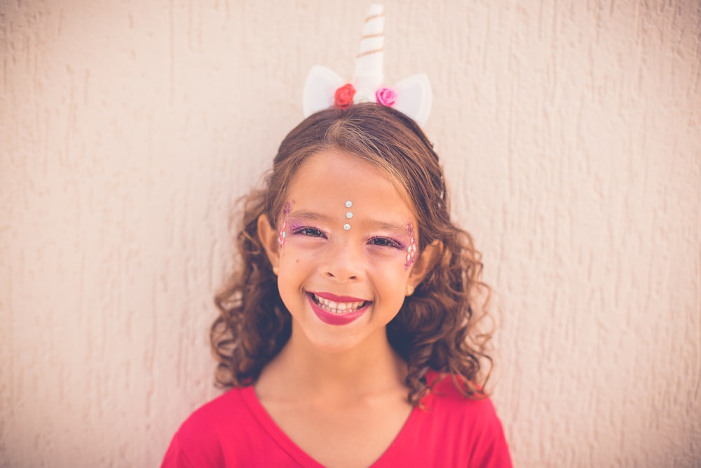 closeup photo of smiling girl wearing red top