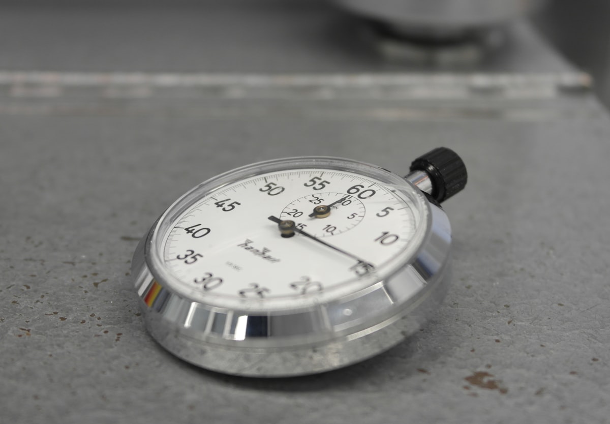 A stopwatch resting on a plain surface, representing the time cost of doing customer research yourself
