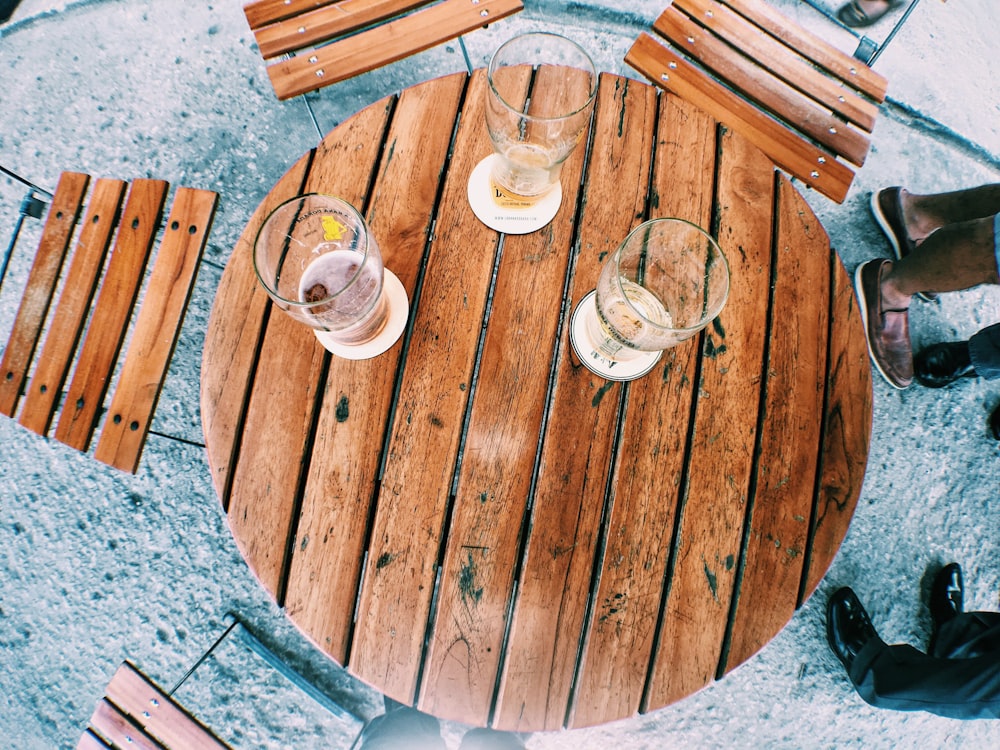 Photographie à plat de verres à pinte vides sur une table à lattes en bois brun