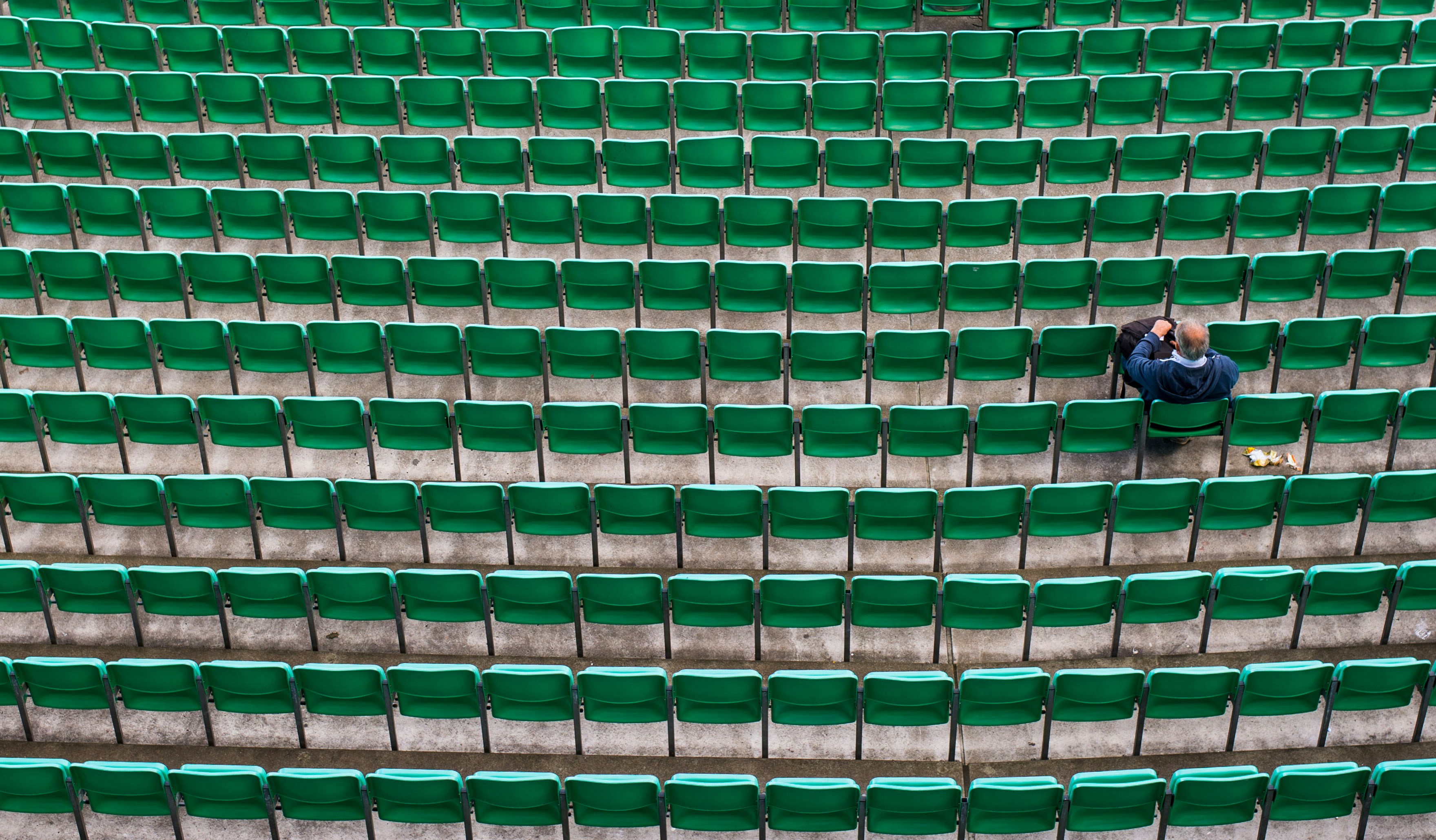 man sitting on bleachers
