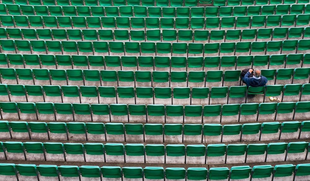 man sitting on bleachers