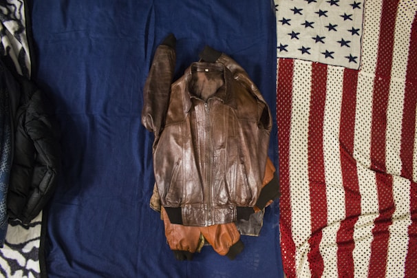Leather jacket laid out flat, mid-process of professional cleaning and conditioning.