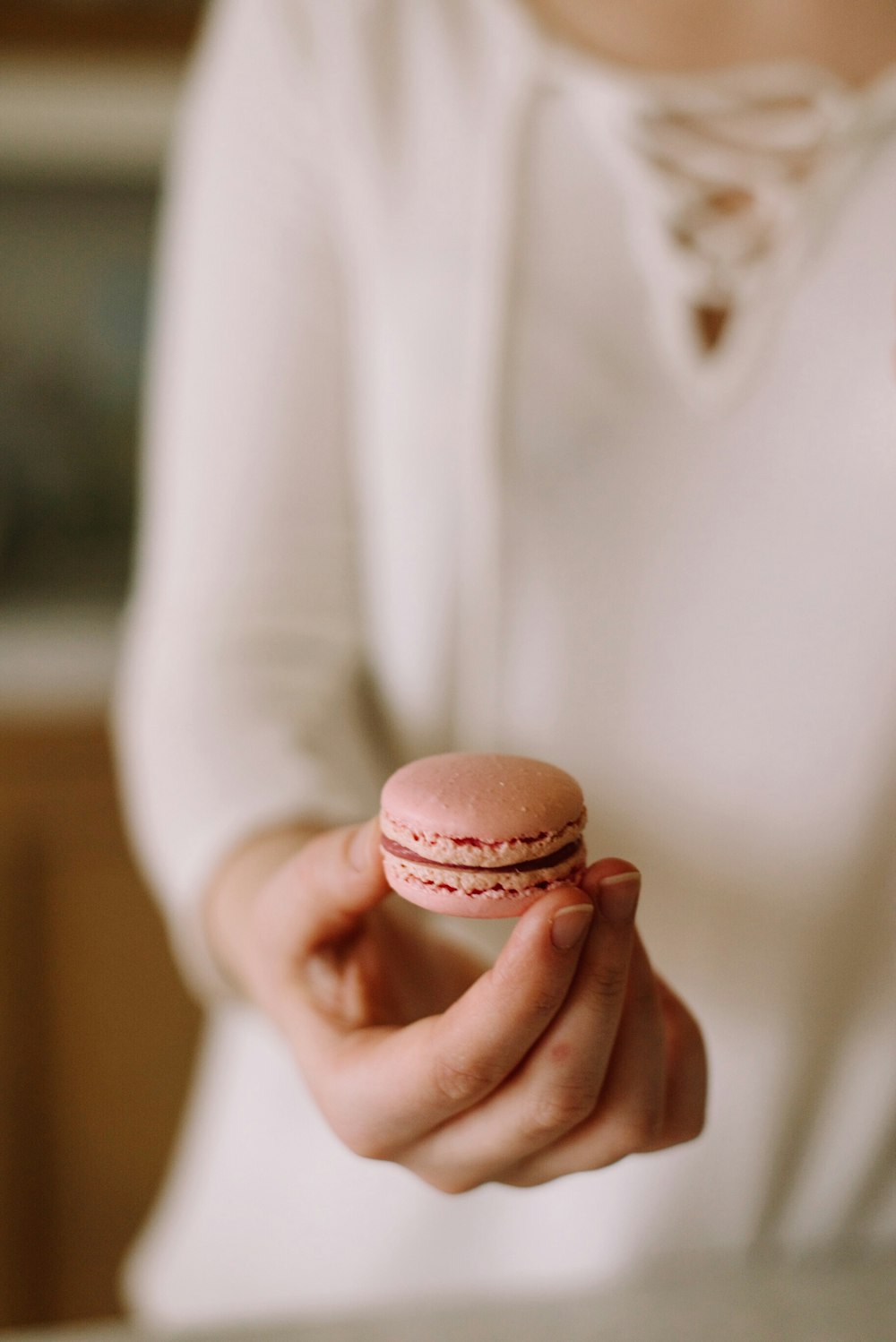 person holding pink macaroon