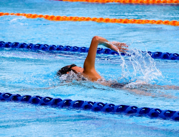 person swimming on an olympic pool