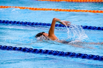 person swimming on an olympic pool