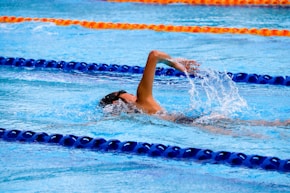 person swimming on an olympic pool