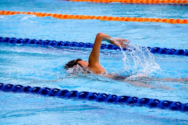 person swimming on an olympic pool