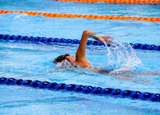 person swimming on an olympic pool