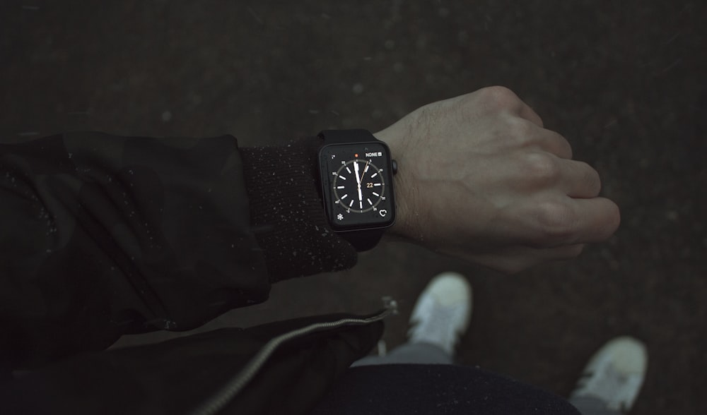 Person, die Space Black Apple Watch mit schwarzem Armband trägt