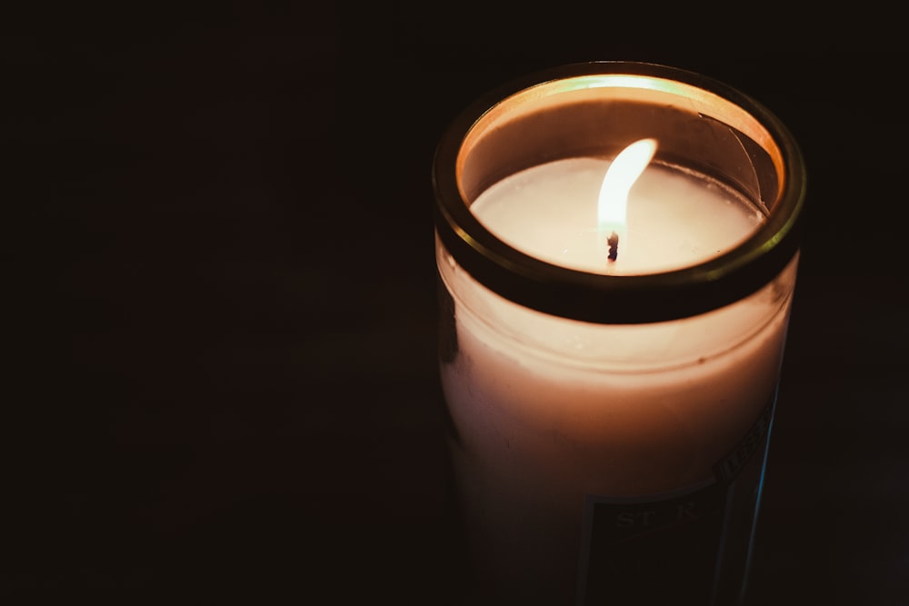 a lit candle sitting on a table in the dark