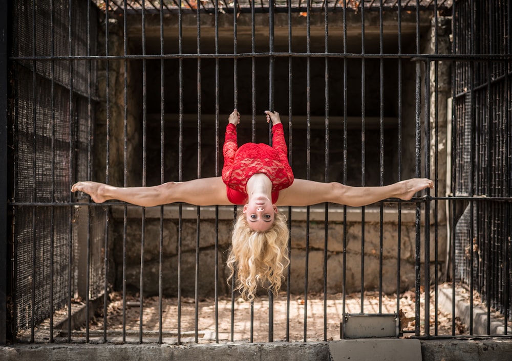 woman bending her legs on metal cage