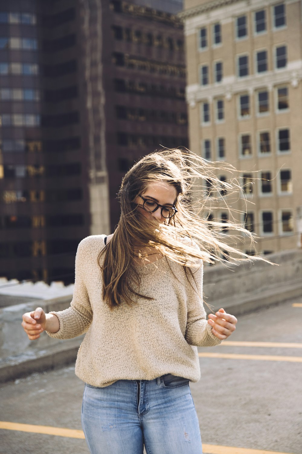 woman standing near building with hair being blown by wind