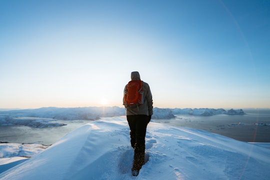 man walking on snow during daytime in Husfjellet Norway