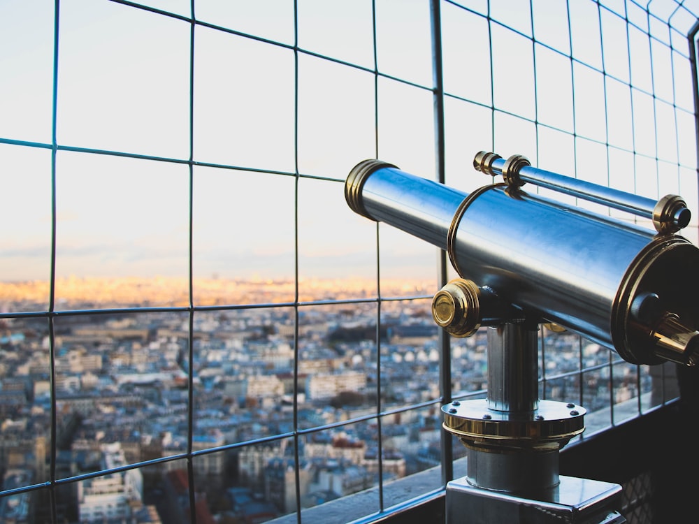 silver telescope near fence