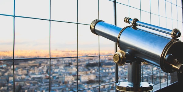 silver telescope near fence