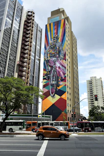 A vibrant city cyclist riding a sleek road bike past colorful murals.