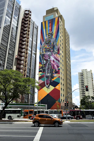 A vibrant city cyclist riding a sleek road bike past colorful murals.