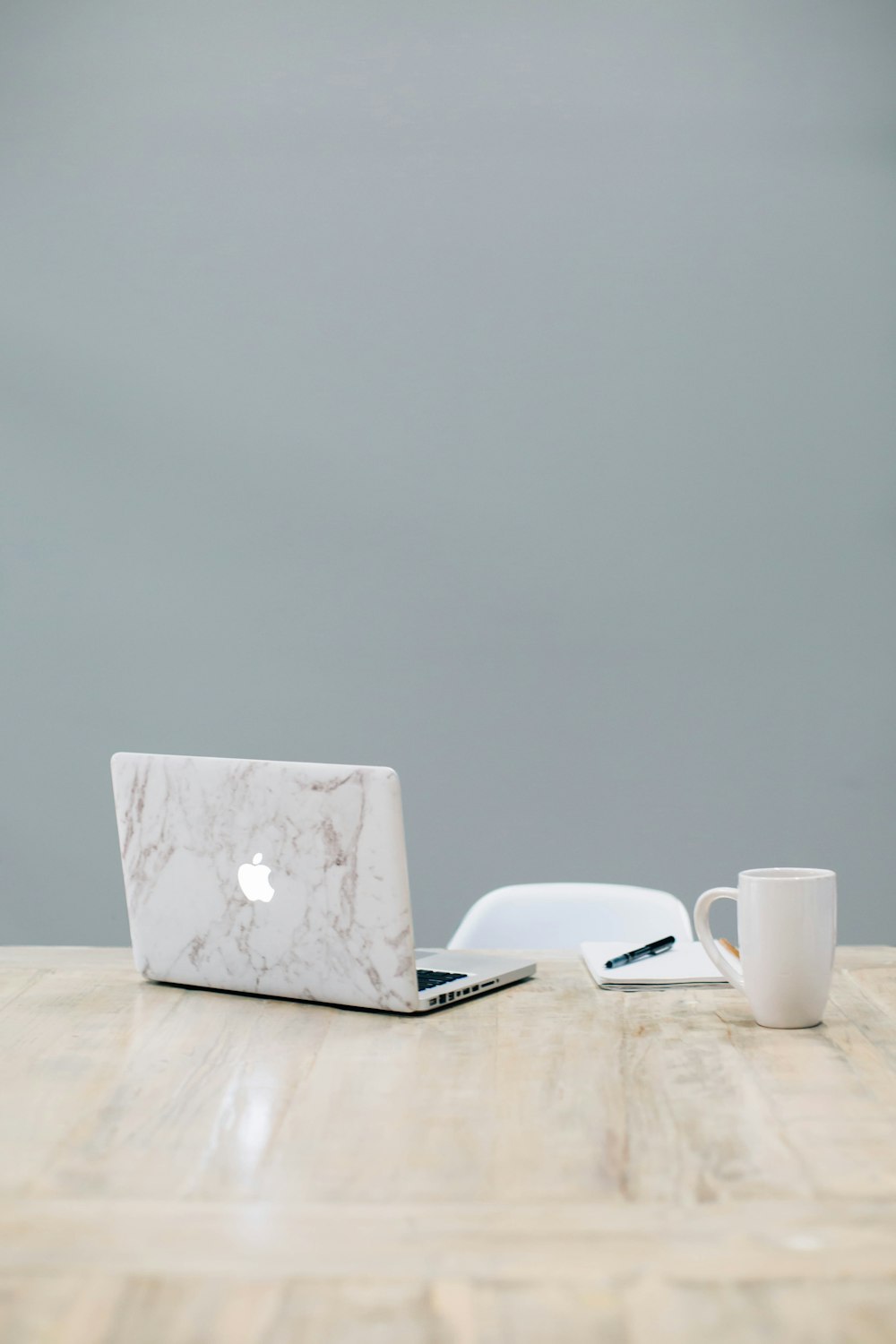 MacBook on table near mug