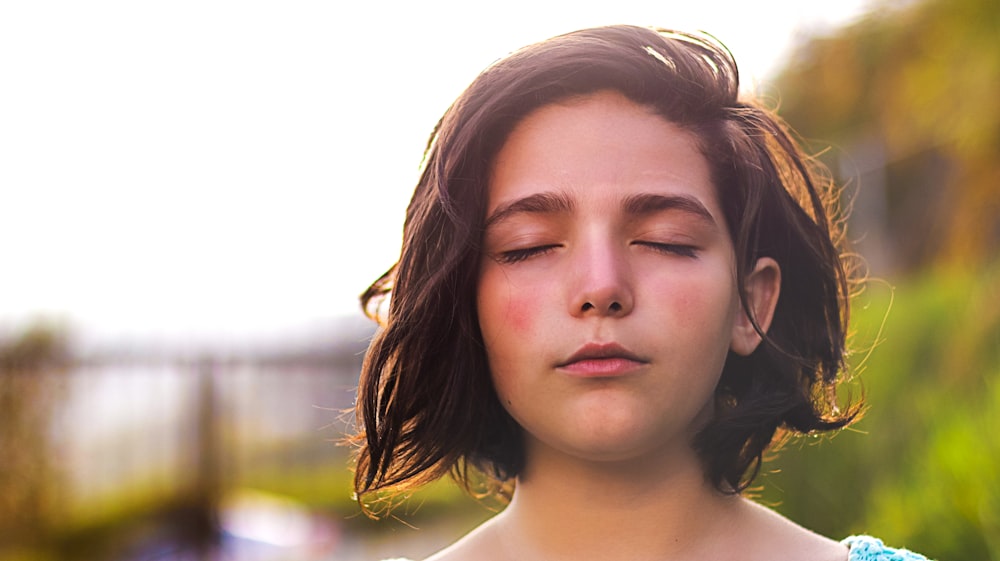 inner engineering, girl in a peaceful, natural setting, with her eyes closed in meditation