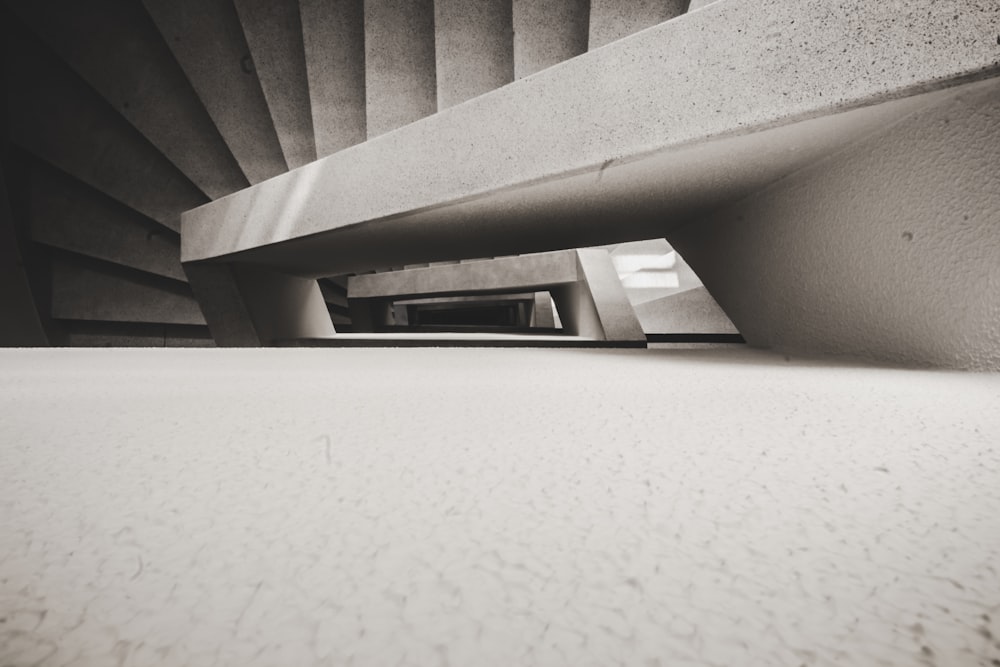 Photographie en plongée d’un escalier en colimaçon en béton blanc