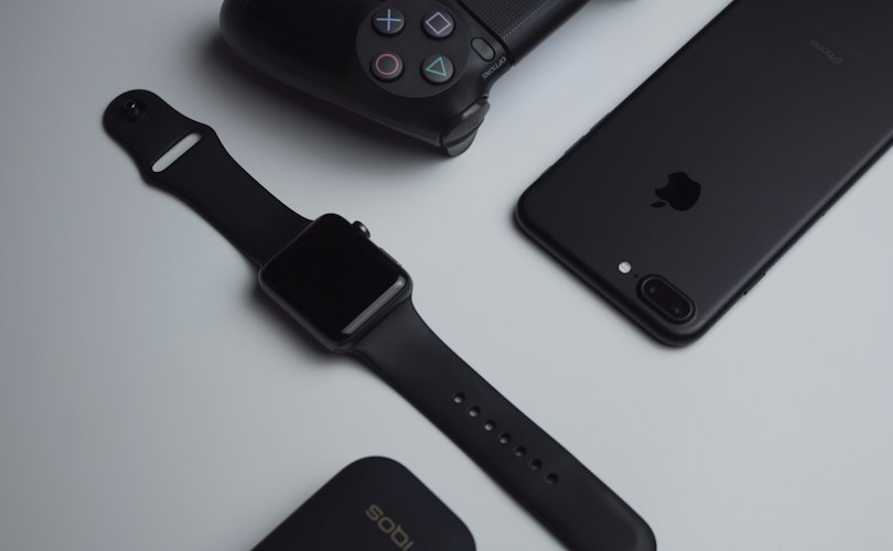 Pair of smart glasses resting on a desk next to a smartphone