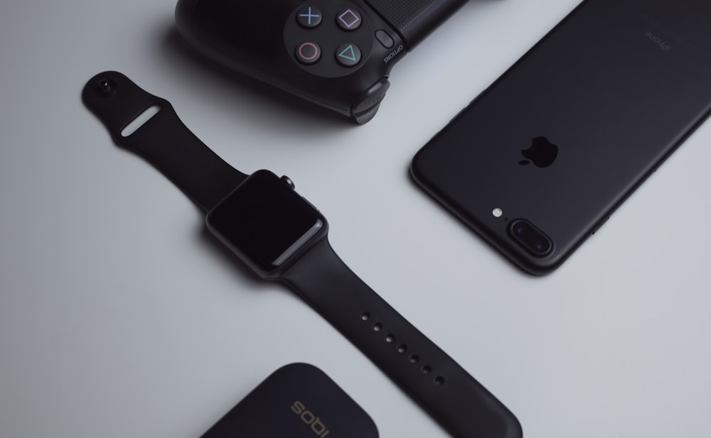 schwarzes iPhone 7 Plus und weltraumgraue Apple Watch mit schwarzem Sportarmband
