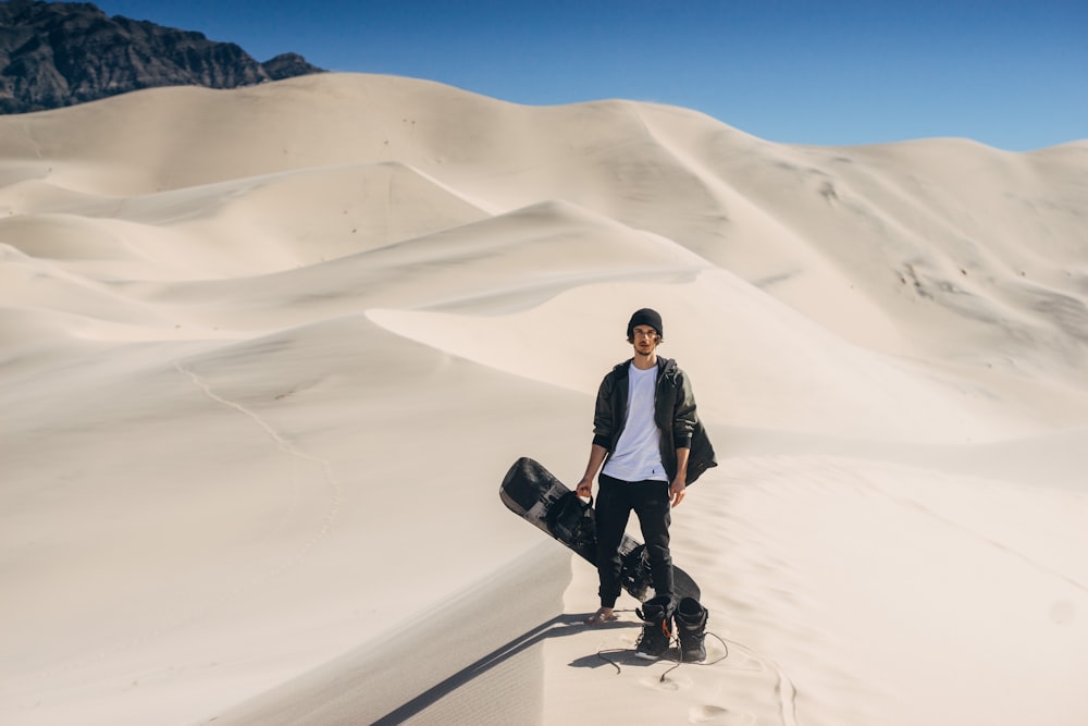 man in black jacket standing on desert