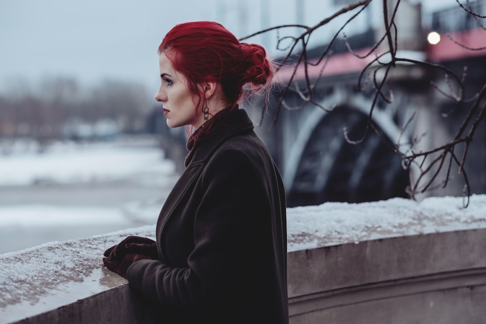 femme vêtue d’un costume noir debout près du bâtiment