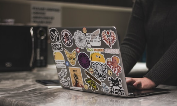 person surfing black laptop near microwave oven