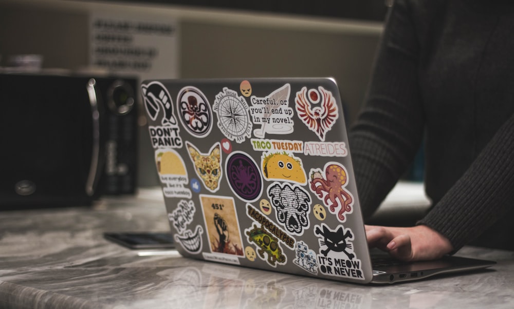 person surfing black laptop near microwave oven