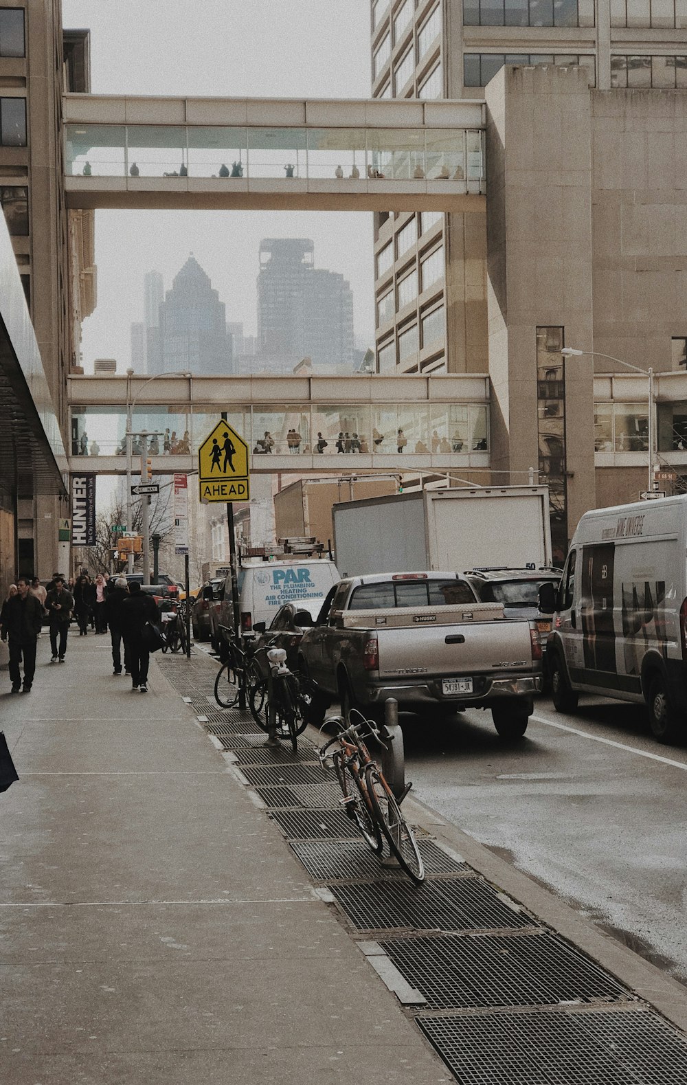 group of people walking beside vehicles near building during daytime