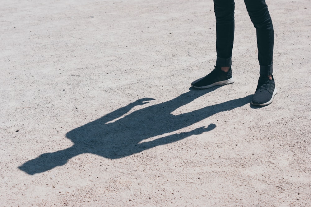 person in black skinny jeans standing on the field