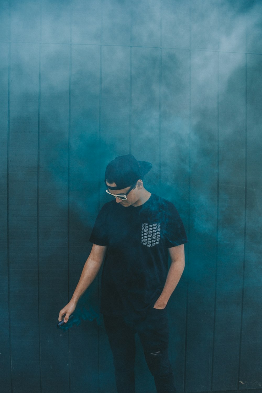 man standing beside gray painted wall