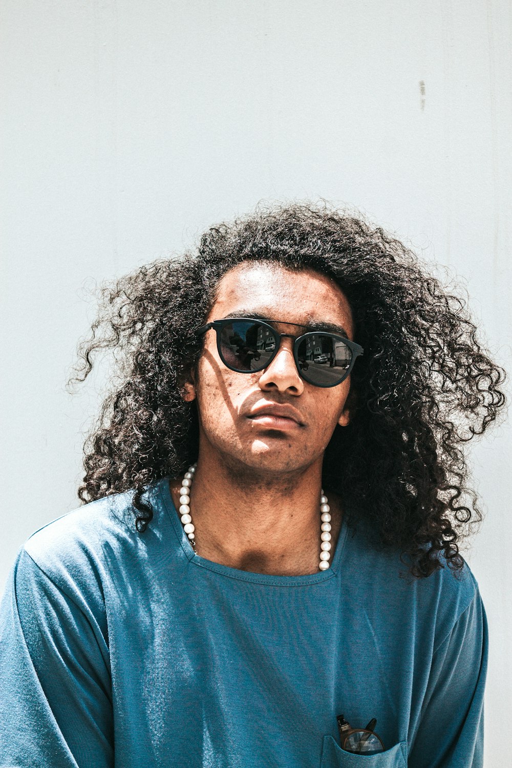 man wearing blue shirt and black lens sunglasses