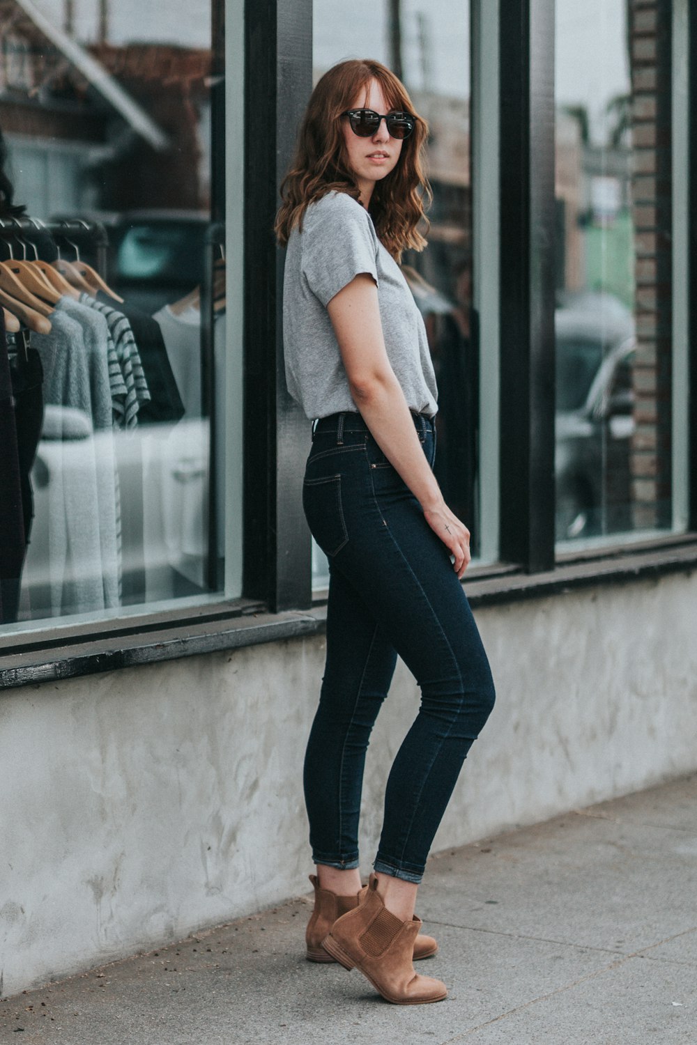 mulher em pé ao lado da loja de roupas