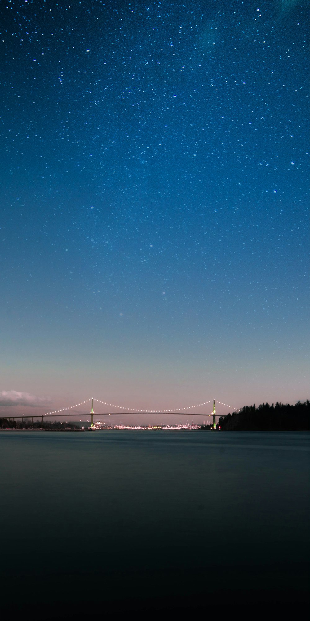 夜の青と白の空にライトアップされた橋