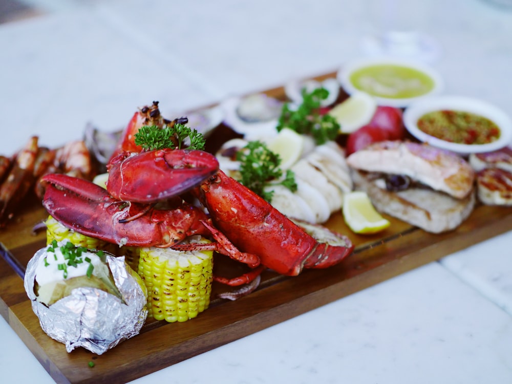 cooked lobsters on brown wooden serving tray with sauce