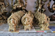 An assortment of miniature human moulds in silver and brass, ready for use in pooja ceremonies.
