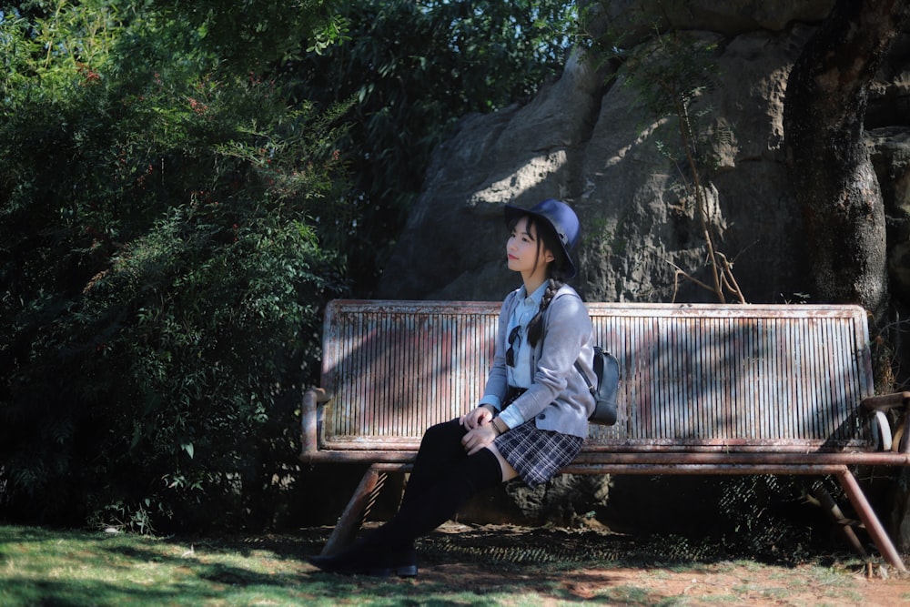 photography of woman sitting on brown bench during daytime