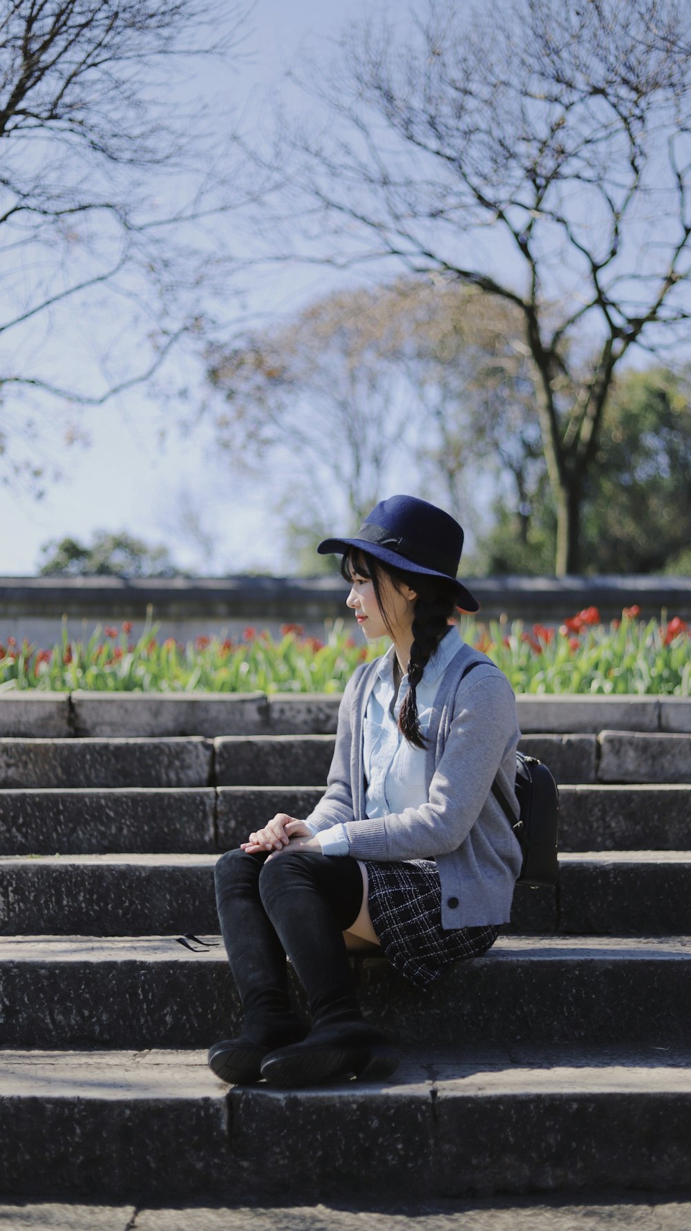 girl sitting on concrete staircase outdoor during daytime