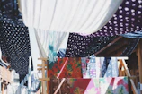 A vibrant display of colorful clothing pieces hanging against a sunlit wall.