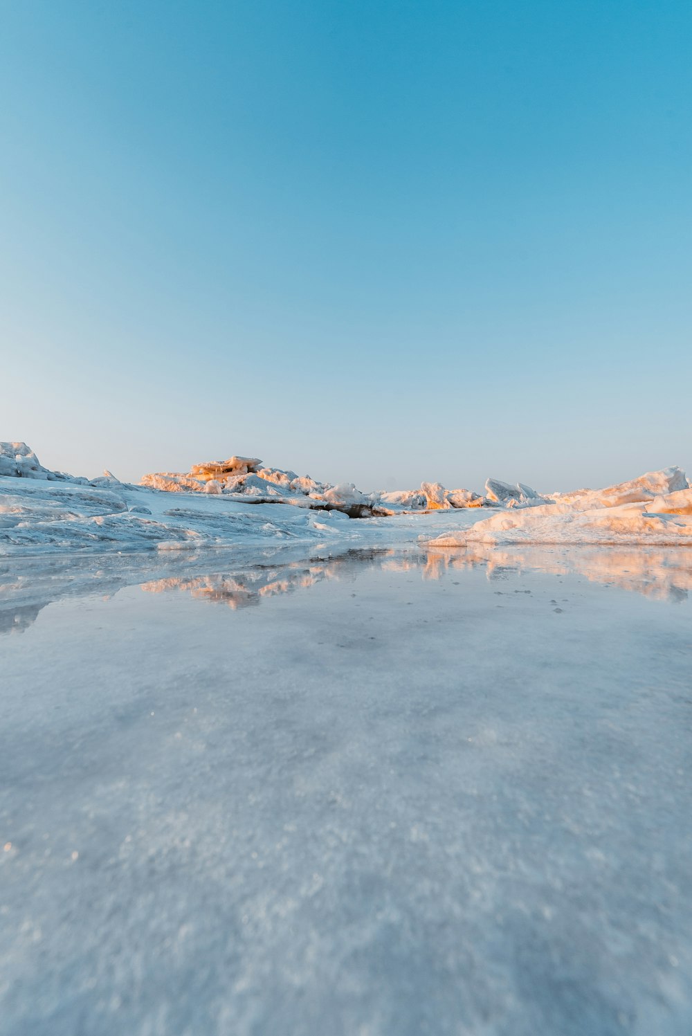 low angle photography of cliff covered with snow